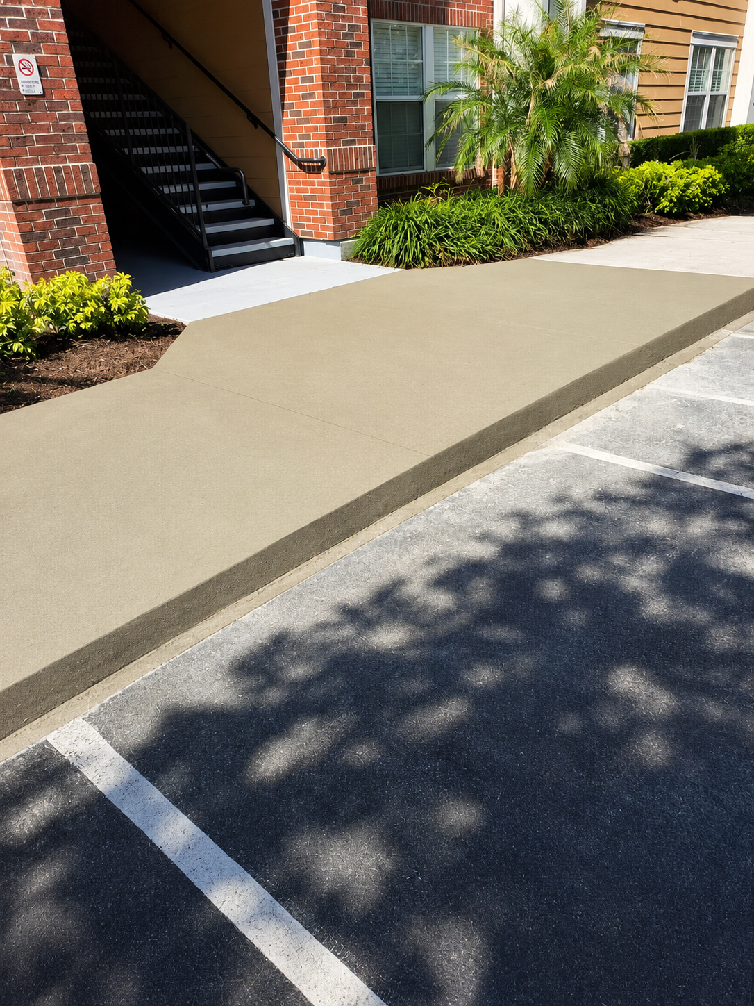 Newly poured concrete walkway at apartment complex entrance